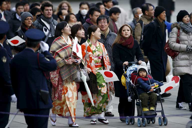 People arrive for an appearance by Japan's Emperor Akihito at the Imperial Palace in Tokyo