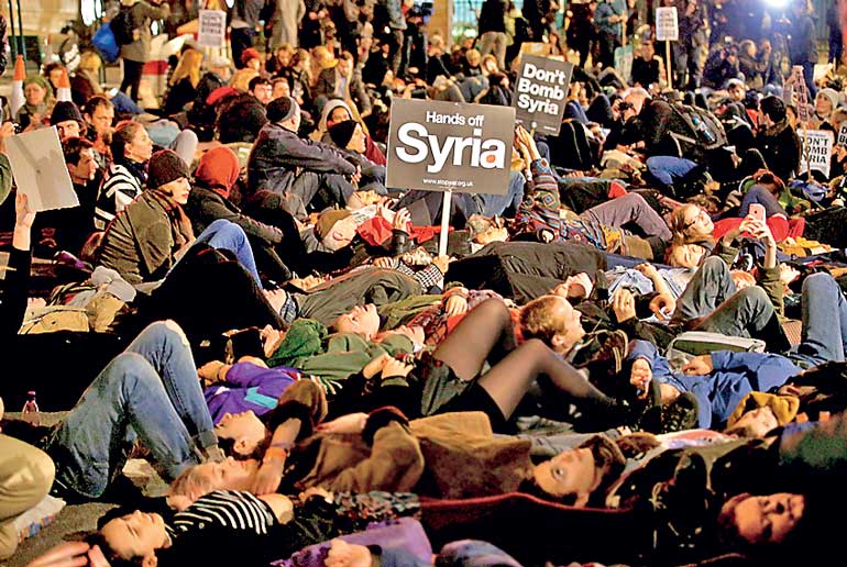 Anti-war protestors block the road during a demonstration outside the Houses of Parliament in London