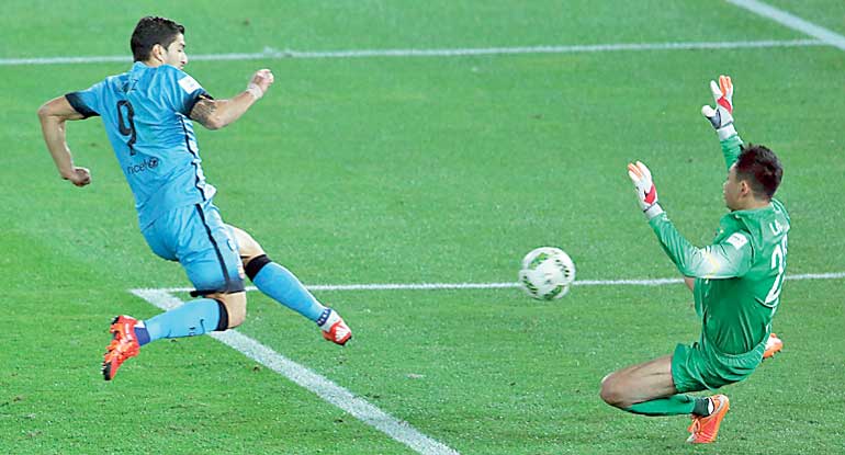 Barcelona's Suarez kicks the ball to score against Guangzhou Evergrande during their Club World Cup semi-final soccer match in Yokohama