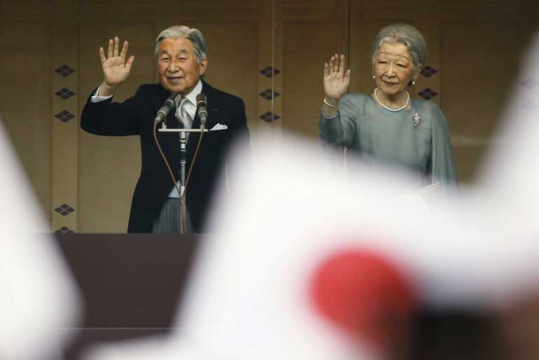 Japan's Emperor Akihito and Empress Michiko wave to well-wishers at the Imperial Palace in Tokyo