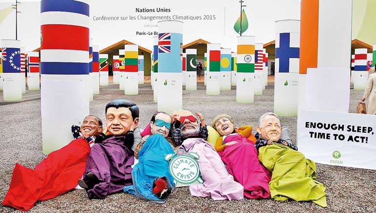 Activists of global anti-poverty charity Oxfam wearing masks depicting some of the world leaders stage a protest outside the venue of the World Climate Change Conference 2015 in Le Bourget, near Paris