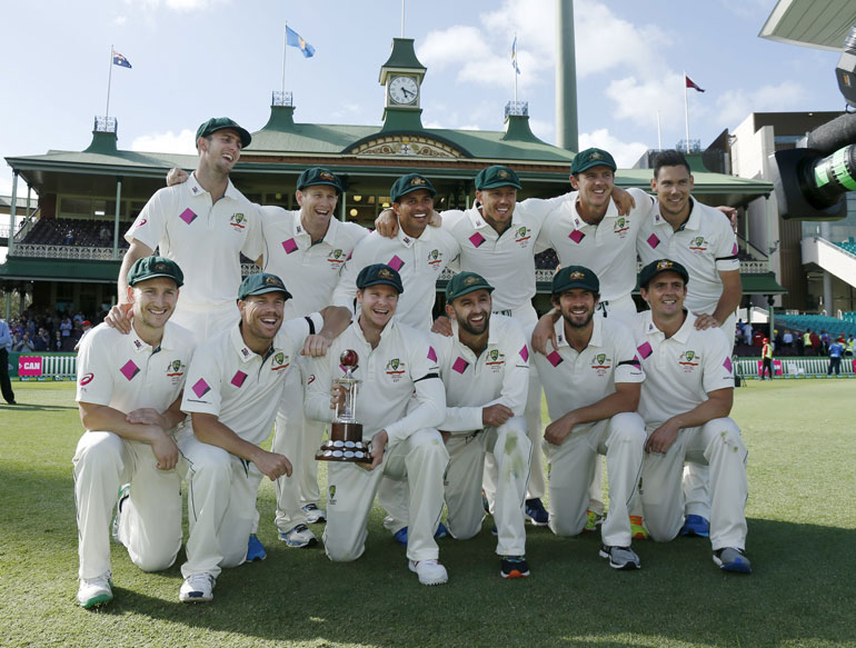 Australia's test cricket captain Steve Smith holds the Frank Worrell trophy among team mates after their third cricket test against the West Indies at the SCG in Sydney