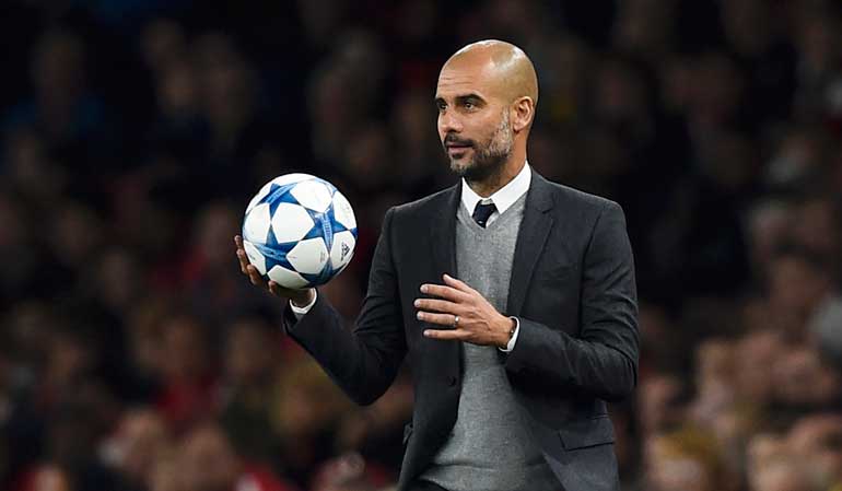 Bayern Munich manager Pep Guardiola holds the ball during his team's Champions League Group F match against  Arsenal at the Emirates Stadium, London, England