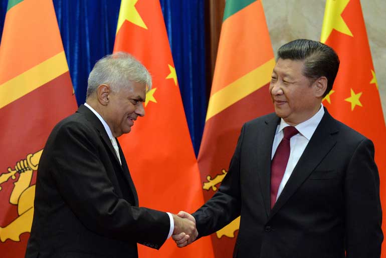 Sri Lankan Prime Minister Ranil Wickremesinghe shakes hands with Chinese President Xi Jinping before a meeting at Great Hall of the People in Beijing