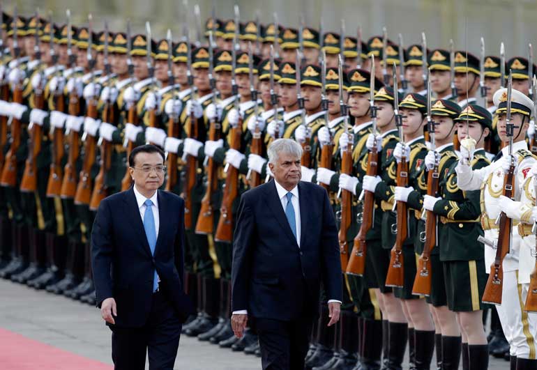 China's Premier Li Keqiang and Sri Lankan PM Wickremesinghe review honour guards during a welcoming ceremony at the Great Hall of the People in Beijing