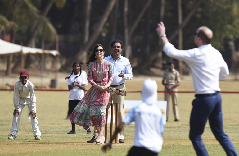 Catherine, Duchess of Cambridge, looks on as she and Britain's Prince William play a game of cricket with Indian children, who are beneficiaries of NGOs, at the Oval Maidan in Mumbai
