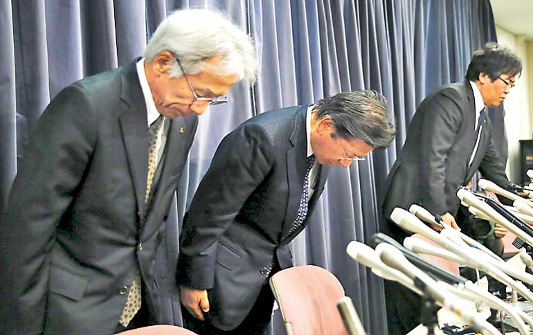 Mitsubishi Motors Corp's President Tetsuro Aikawa bows with other company executives during a news conference to brief about issues of misconduct in fuel economy tests at the Land, Infrastructure, Transport and Tourism Ministry in Tokyo, Japan