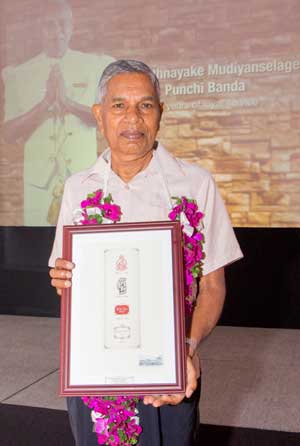Rathnayake-Mudiyanselage-Punchi-Banda-holding-the-award-to-commemorate-the-long-service-at-the-Galle-Face-Hotel