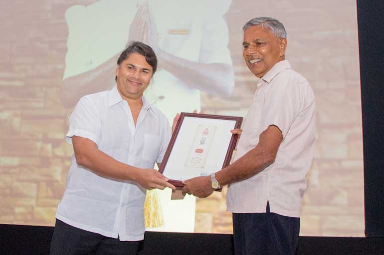 Sanjeev-Gardiner-handing-Banda-an-award-to-commemorate-the-long-service-at-the-Galle-Face-Hotel