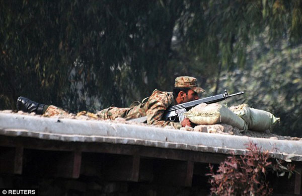 2416060C00000578-2875729-A_Pakistani_soldier_takes_up_a_position_above_a_road_near_the_sc-a-39_1418838309208